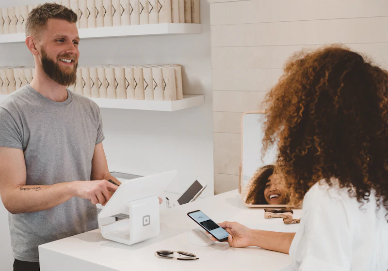 Customer paying with a phone at a small shop counter
